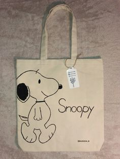 a snoopy bag is on the floor with a tag hanging from it's side