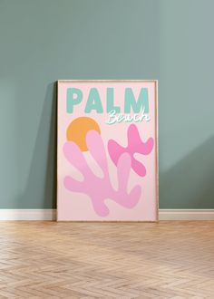 a pink poster with the words palm beach on it in front of a green wall