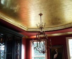 a chandelier hanging from the ceiling in a room with red walls and windows