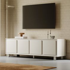 a white entertainment center with a flat screen tv mounted on the wall