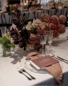 the table is set with silverware and flowers