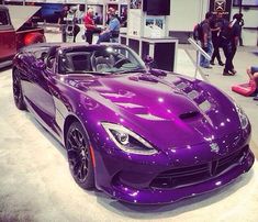 a purple sports car on display at an auto show