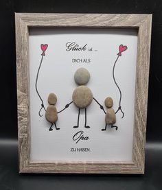 a family is holding hands with two rocks in the shape of people and one heart