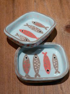 two small dishes with fish painted on them