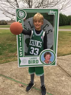 a young boy is holding up a poster with a photo of him as a basketball player