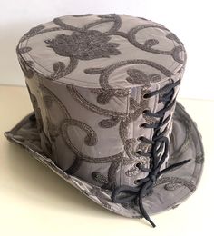 Victorian steampunk gothic top hat is made of hand crafted embroidering in dull vintage colours of khakis and deep olives. please refer to photos  It is very well made and is made of a silk netting type of fabric. It is fully lined with black satin fabric. The front & back of the hat has black ribbon corseted.  It is available in Size in 57cm Height 18cm   this is full head hat and not mini hat Please note any markings & traces of glue are characteristics of the fabric and not defective  Thank y Elegant Steampunk, Foam Wigs, Vintage Colours, Black Satin Fabric, Gothic Tops, Mini Hat, Top Hats, Victorian Steampunk, Pleated Top