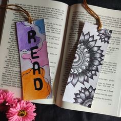 two bookmarks with the words read and sunflowers on them next to a pink flower