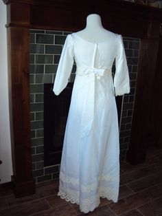 a white dress on display in front of a fireplace