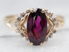 One of our favorite gemstones is a gorgeous rhodolite garnet with rich, raspberry tones. We've set this garnet in the center of glittering diamonds to bring plenty of sparkle. Metal: 14K Yellow Gold Gem: Rhodolite Garnet 2.20 Carats Gem Measurements: 5.9 x 10.7 mm, Oval Accents: 14 Diamonds .16 Carats, I-L in Color, SI in Clarity Ring Size: 10Marks: “14K” Stamped on the inside band 10 Marks, Rhodolite Garnet Ring, Garnet And Diamond Ring, Garnet Engagement Ring, Right Hand Ring, Red Stone Ring, Right Hand Rings, Diamond Glitter, Hand Ring