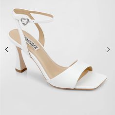 a pair of white high heeled shoes with ankle straps and an open - toe