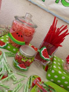 a table topped with lots of candy and watermelon themed items on top of it