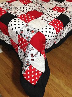 the bed is made up with red and white polka dot quilts on it's cover