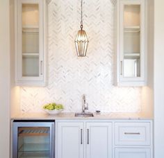 a kitchen with white cabinets and an open wine cooler in the corner next to it