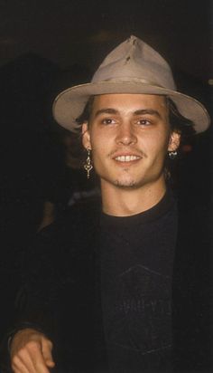 a young man wearing a hat and black shirt