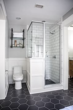 a bathroom with black and white tile flooring next to a walk - in shower