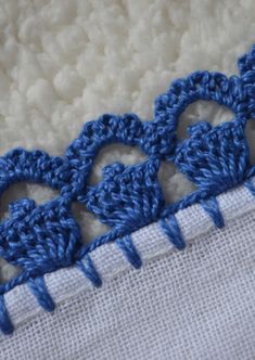 closeup of blue crochet stitching on white fabric