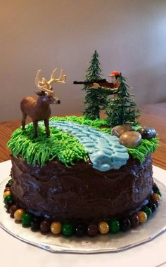 a chocolate cake with green frosting and decorations on top, sitting on a plate