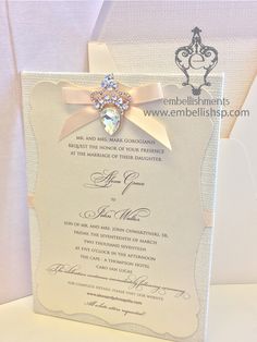 a wedding card with a bow and diamond brooch