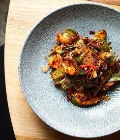 a blue plate topped with food on top of a wooden table