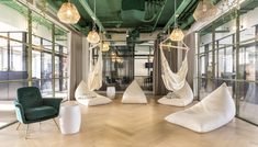 an office with hammocks hanging from the ceiling and two chairs in front of them