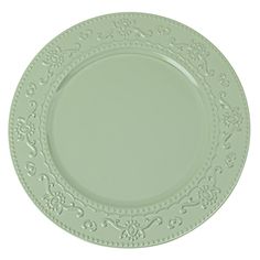 a green plate with ornate designs on it's rim and sides, set against a white background