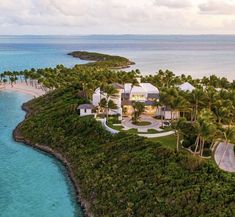 an aerial view of a tropical island with white houses and palm trees on the shore