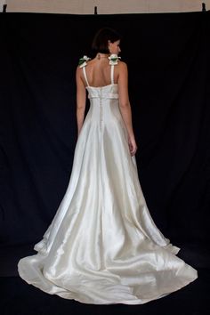 a woman in a white wedding dress is standing back to back with her hands on her hips