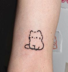 a small dog tattoo on the left inner arm and wrist, which is drawn in black ink