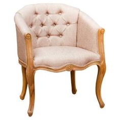 a wooden chair with beige upholstered fabric on the back and arms, sitting in front of a white background