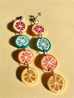 four slices of fruit are hanging from earrings