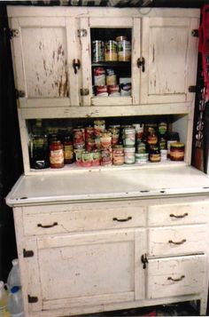 an old white cupboard with spice jars on it