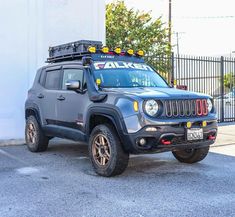 a gray jeep parked in front of a white building