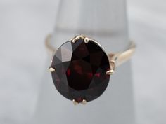 The shoulders of this solitaire feature a sleek design, all the better to reflect light into the gorgeous center stone. We've set this vintage mounting with a lovely, deep red garnet. Flashing with bright crimson highlights, this gem shines with fire and light!Metal: 14K Yellow Gold Gem: Garnet 6.30 CaratsGem Measurements: 11.9 x 10.3 mm, OvalRing Size: 6.25Marks: “14K” Stamped on the inside band Garnet And Gold, Gold Solitaire Ring, Garnet Rings, Red Garnet, Solitaire Ring, Deep Red, Sleek Design, Garnet, Highlights