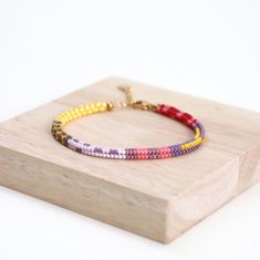 This handwoven multi-color beaded bracelet is a vibrant accessory that adds a pop of color to any outfit. Crafted with meticulous care, it features a colorful box chain design, making it perfect for summer vibes. Each bead is delicately strung together to create a unique and eye-catching pattern, making this bracelet a stylish addition to your jewelry collection. Perfect for adding a playful touch to your look, this seed bead bracelet is sure to become a staple accessory for any fashion-forward Multicolor Braided Bead Bangle Bracelet, Multicolor Braided Bracelet Bangle, Multicolor Hand-strung Braided Bangle Bracelet, Multicolor Braided Bangle Bracelet, Multicolor Tiny Beads Braided Bracelet As Gift, Multicolor Braided Bracelets With Tiny Beads As Gift, Multicolor Braided Bracelet With Tiny Beads For Gifts, Multicolor Friendship Braided Bracelets With Letter Beads, Multicolor Bohemian Braided Bracelets With Letter Beads