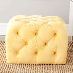 a yellow ottoman sitting on top of a rug