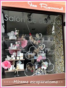 a window display in a store with pink flowers and hearts on the windows sill