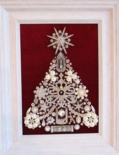 a christmas tree made out of pearls and other jewels in a frame on a wall