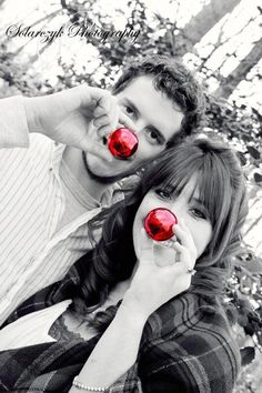 a man and woman holding up two red balls in front of their face, with the caption's name on them