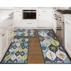 a kitchen with white cabinets and an area rug in the floor that looks like tiles