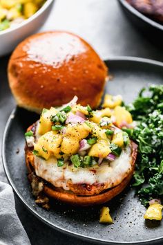 a plate with some food on it next to a roll and salad in a bowl