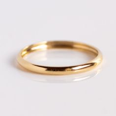 a gold wedding ring on a white background