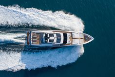 an aerial view of a motor boat in the middle of the ocean with water behind it