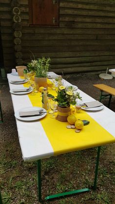 a table set up with plates and glasses on it for an outdoor dinner or party