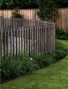 a wooden fence in the middle of some grass