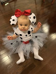 a baby girl dressed in a dalmatian costume