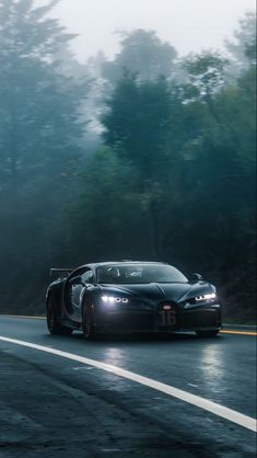 the bugatti is driving down the road in the rain