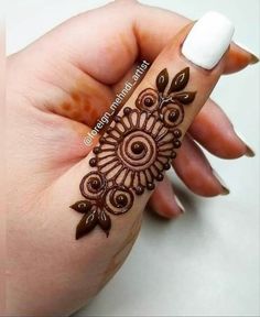 a woman's hand with henna tattoos on it