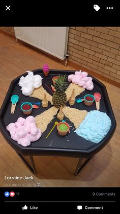 a black table topped with lots of cake and cupcakes on top of it