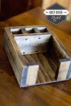 a wooden box sitting on top of a table next to a sign that says grey river project