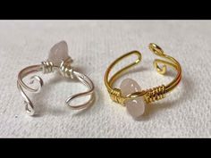 two rings sitting on top of a white cloth covered table next to each other with wire wrapped around them